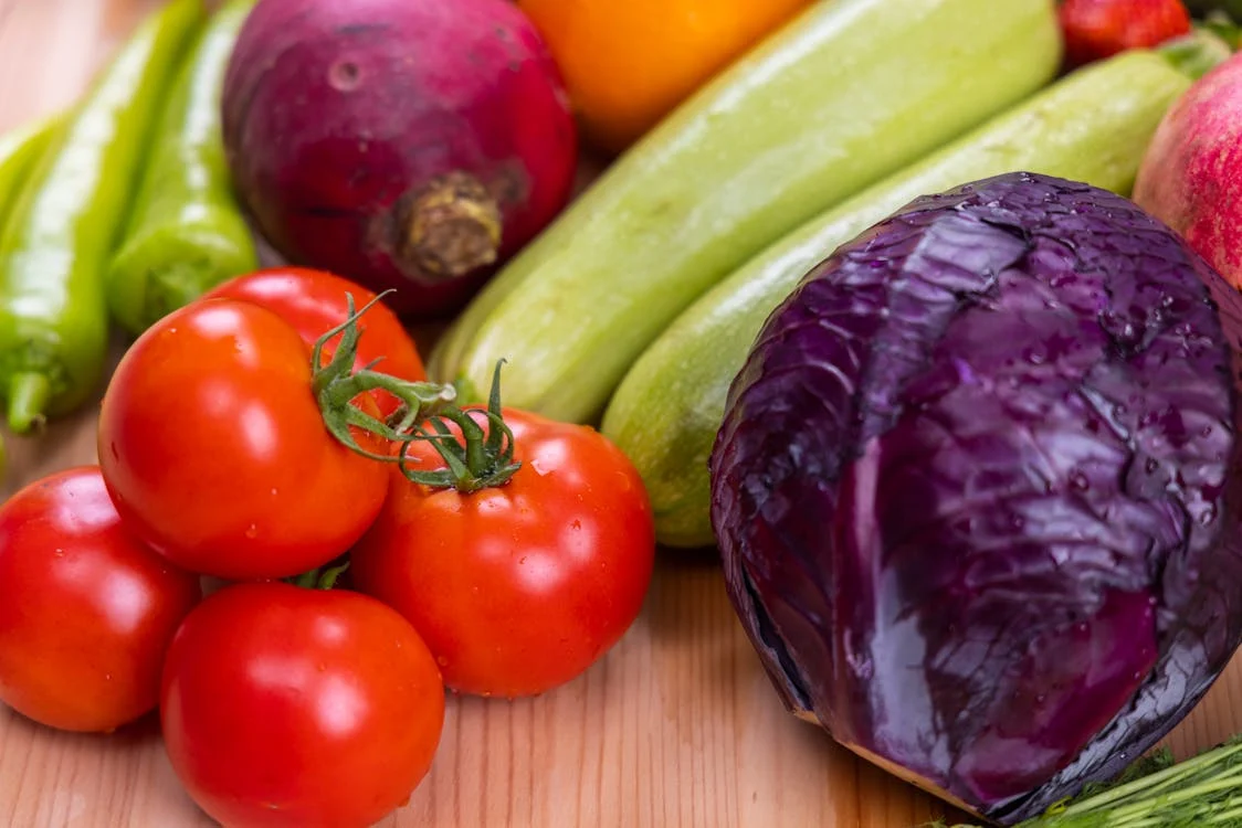 Fresh colorful vegetables and grains arranged on a wooden table representing balanced nutrition
